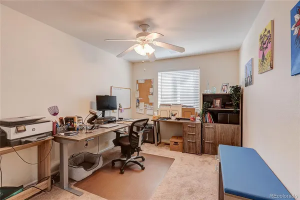 a view of a workspace with furniture and a window