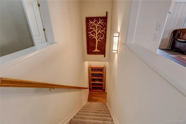 a view of a hallway with wooden floor and staircase