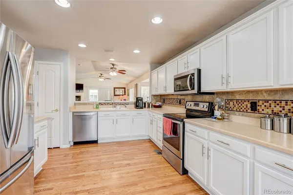 a kitchen with white cabinets and stainless steel appliances