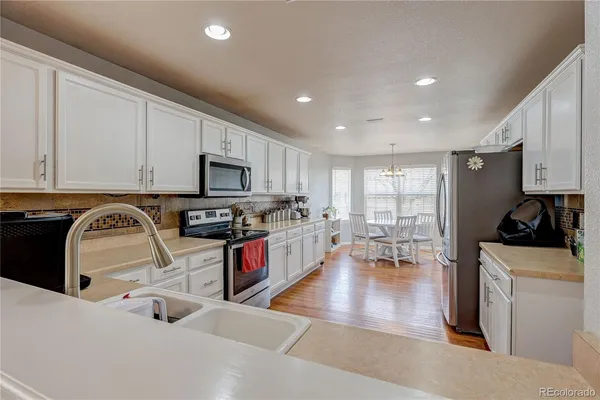 a kitchen with granite countertop a stove a sink a microwave and refrigerator