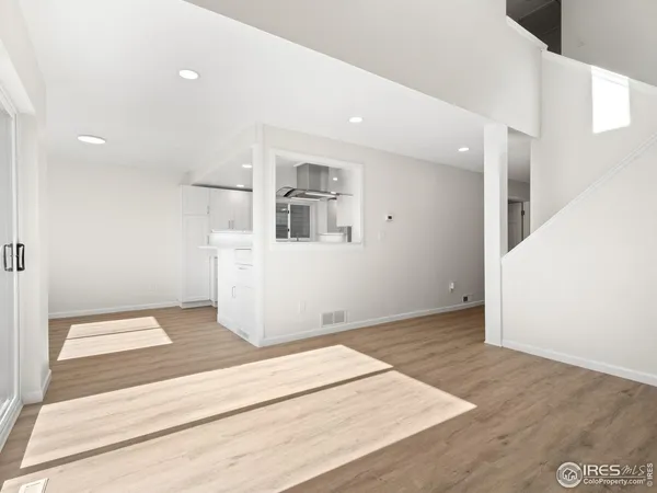 a view of a kitchen with wooden floor and windows