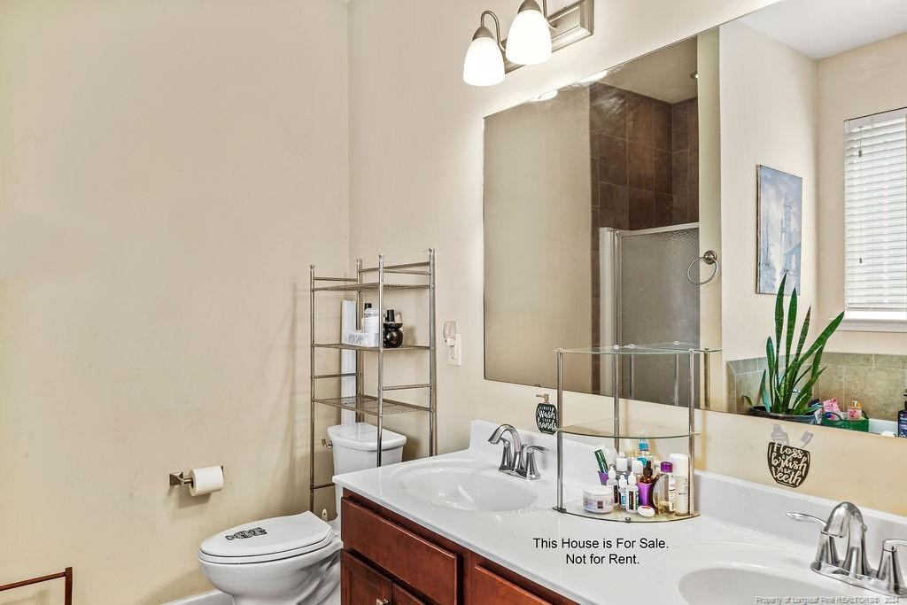 113 Meherrin Loop Raeford, NC 28376 - Photo 18 of 27 a bathroom with a sink a toilet and shower curtain