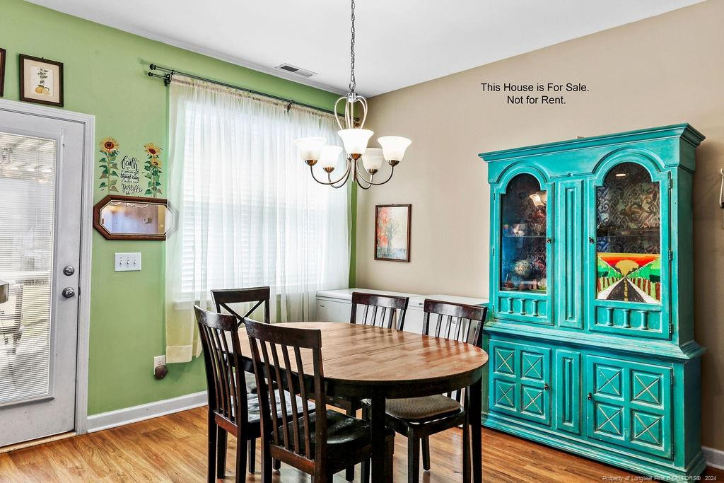 113 Meherrin Loop Raeford, NC 28376 - Photo 23 of 27 a dining room with furniture a chandelier and wooden floor