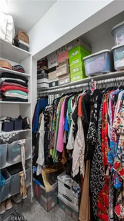a view of walk in closet with clothes and shoes