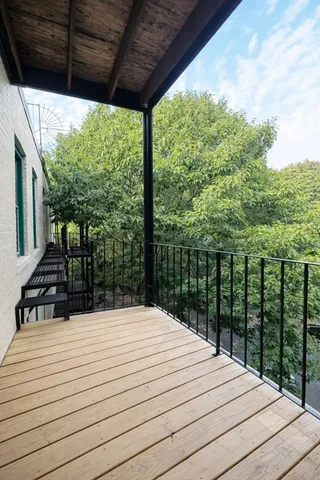 a bed sitting in a balcony next to a yard