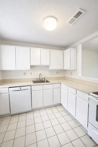 a kitchen with a sink window and cabinets