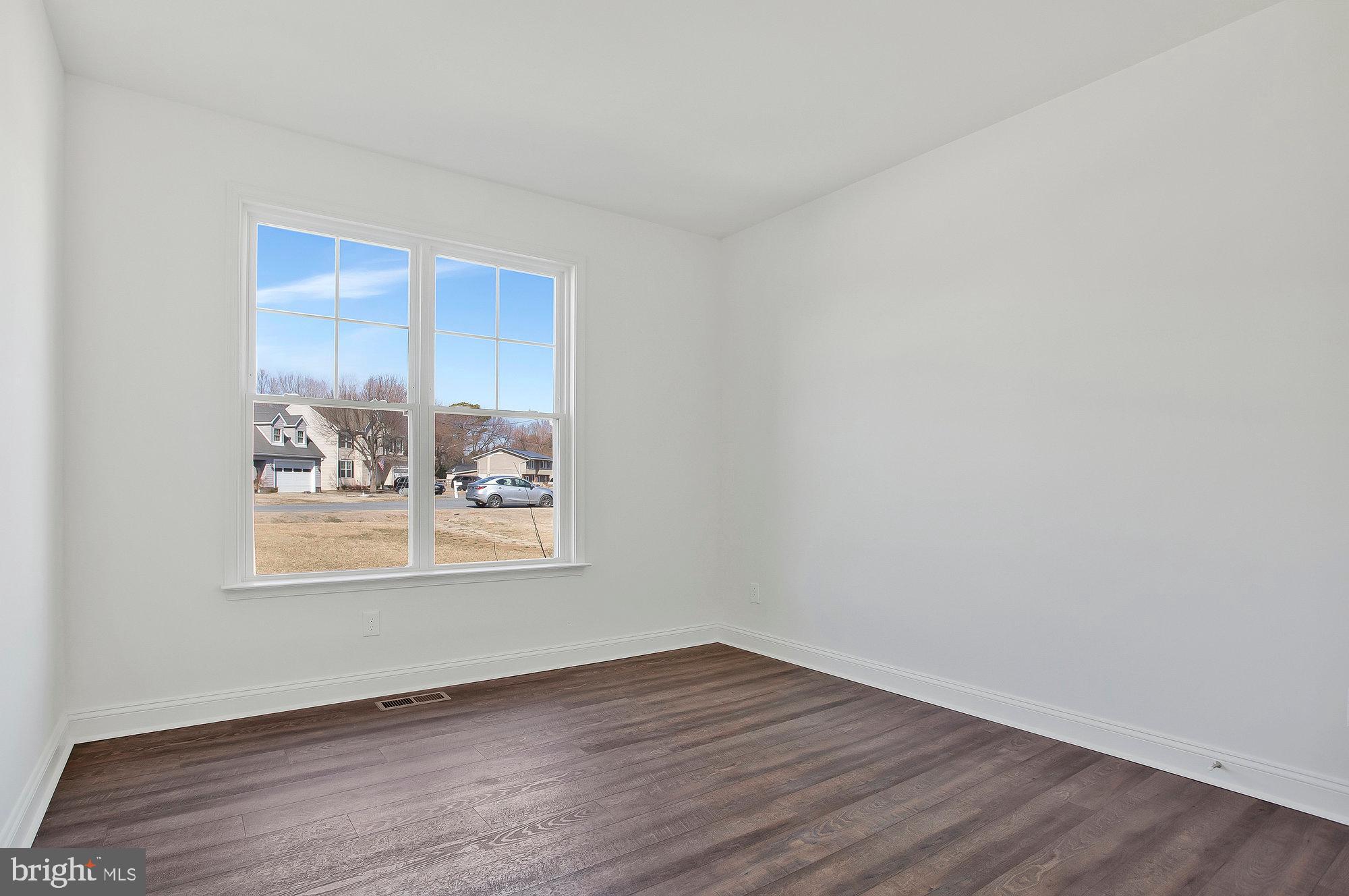 312 Queens Colony High Road Stevensville, MD 21666 - Photo 31 of 57 a view of an empty room with wooden floor and a window