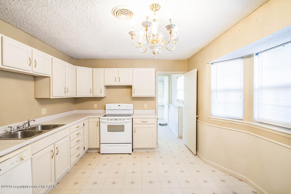 4314 Crockett Street Amarillo, TX 79110 - Photo 2 of 21 a kitchen with a stove a sink and a refrigerator
