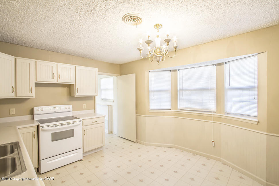4314 Crockett Street Amarillo, TX 79110 - Photo 4 of 21 a kitchen with a stove a sink and a refrigerator