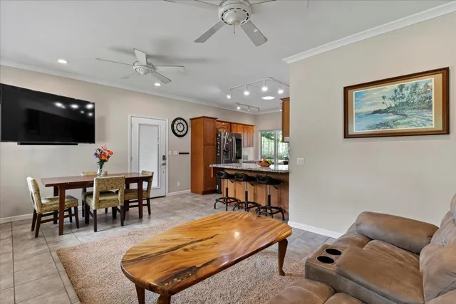 a living room with furniture a flat screen tv and kitchen view