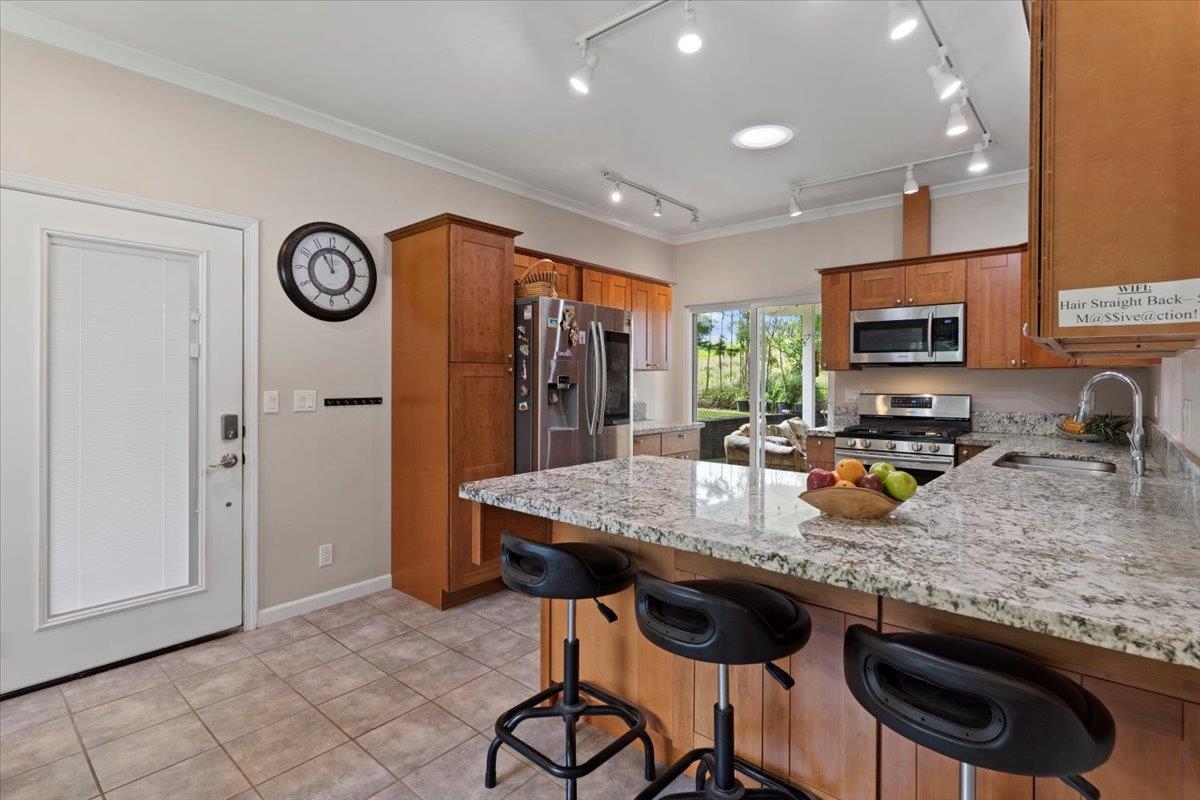 200 Awalau Road, Unit B Haiku, HI 96708 - Photo 19 of 39 a kitchen with stainless steel appliances granite countertop a stove top oven a sink a dining table and chairs