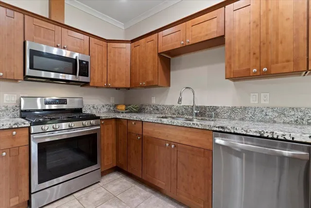 a kitchen with stainless steel appliances granite countertop a sink stove and microwave