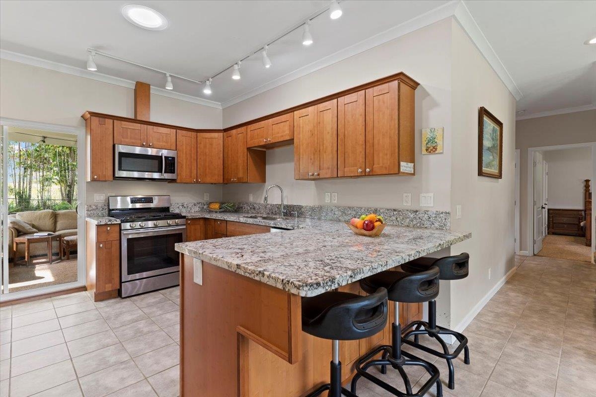 200 Awalau Road, Unit B Haiku, HI 96708 - Photo 2 of 39 a kitchen with granite countertop a stove top oven a sink dishwasher and cabinets with wooden floor