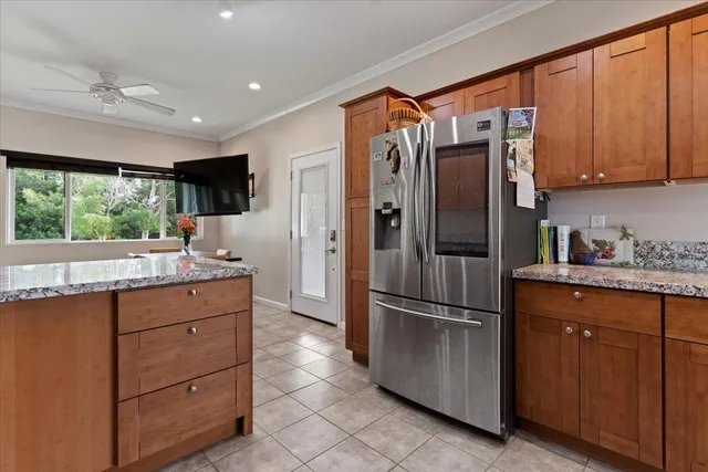 a kitchen with granite countertop stainless steel appliances a refrigerator cabinets and a sink