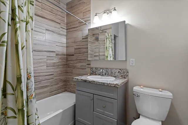 a bathroom with a granite countertop sink toilet and shower