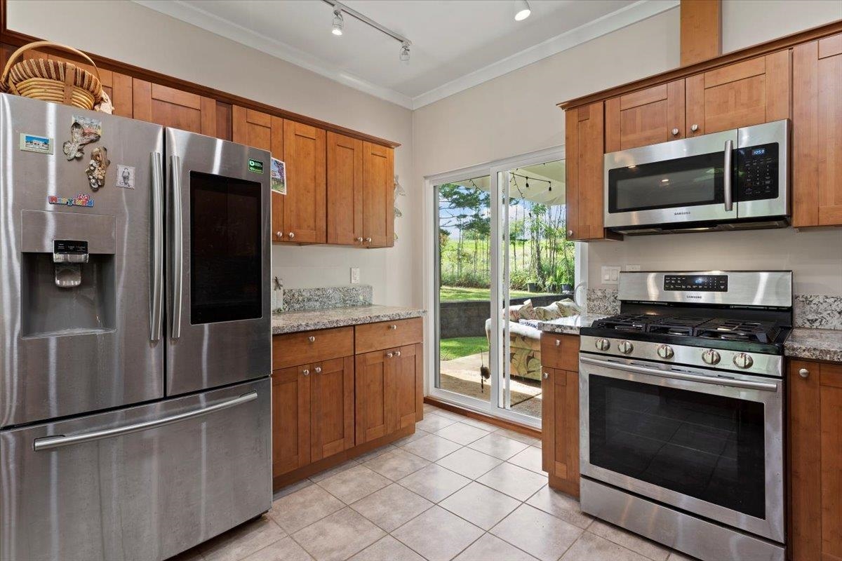 200 Awalau Road, Unit B Haiku, HI 96708 - Photo 7 of 39 a kitchen with stainless steel appliances granite countertop a stove microwave and refrigerator
