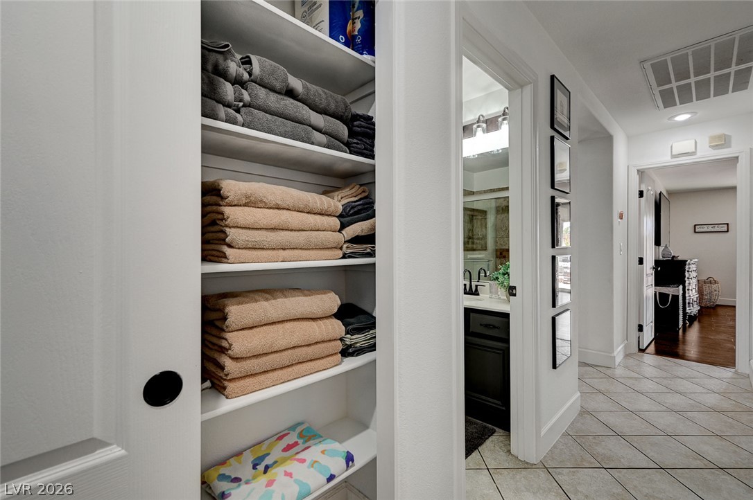 1072 Reed Point Court Henderson, NV 89002 - Photo 38 of 60 Well-organized shelving provides ample storage in this central hallway, leading to a vanity-equipped bathroom and other living spaces.