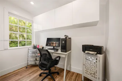 a view of a workspace with furniture and a window