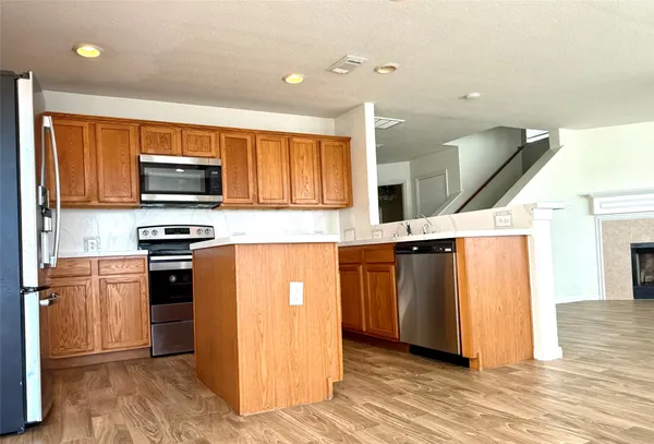 a kitchen with stainless steel appliances granite countertop a stove a sink and a refrigerator