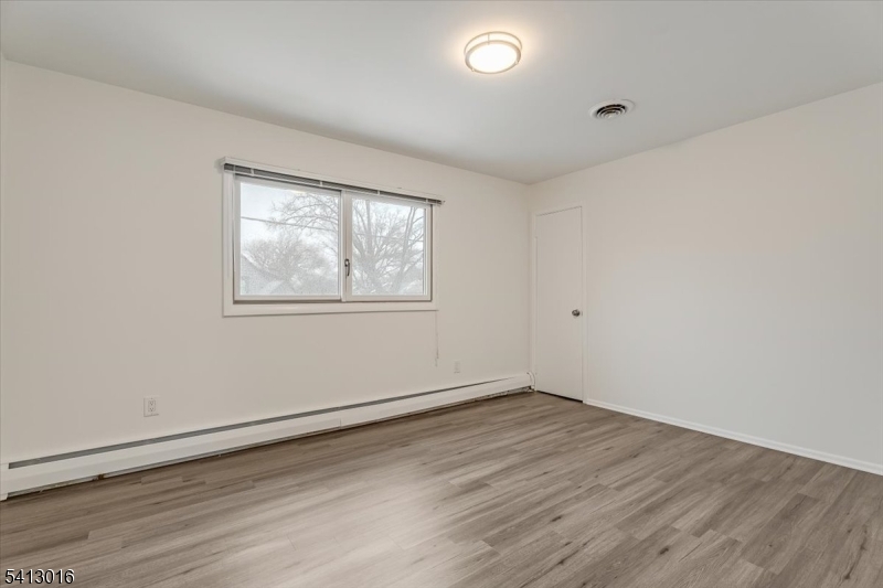 35 Field Road, Unit 2 Maplewood, NJ 07040 - Photo 11 of 13 an empty room with wooden floor and windows