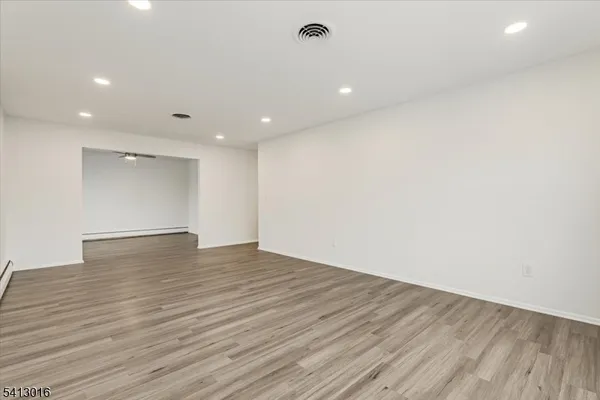 a view of empty room with wooden floor