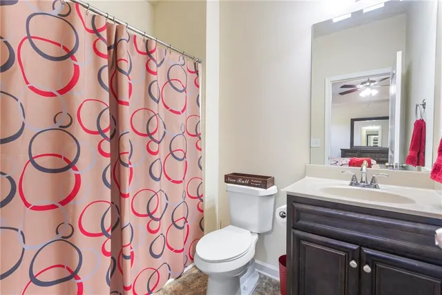 a bathroom with a sink a toilet and shower curtain