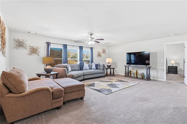 a view of a white house with a swimming pool and lawn chairs under an umbrella
