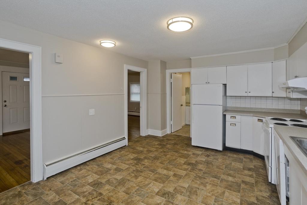 177 Marion Street Chicopee, MA 01013 - Photo 8 of 36 a view of a kitchen with refrigerator and white cabinets