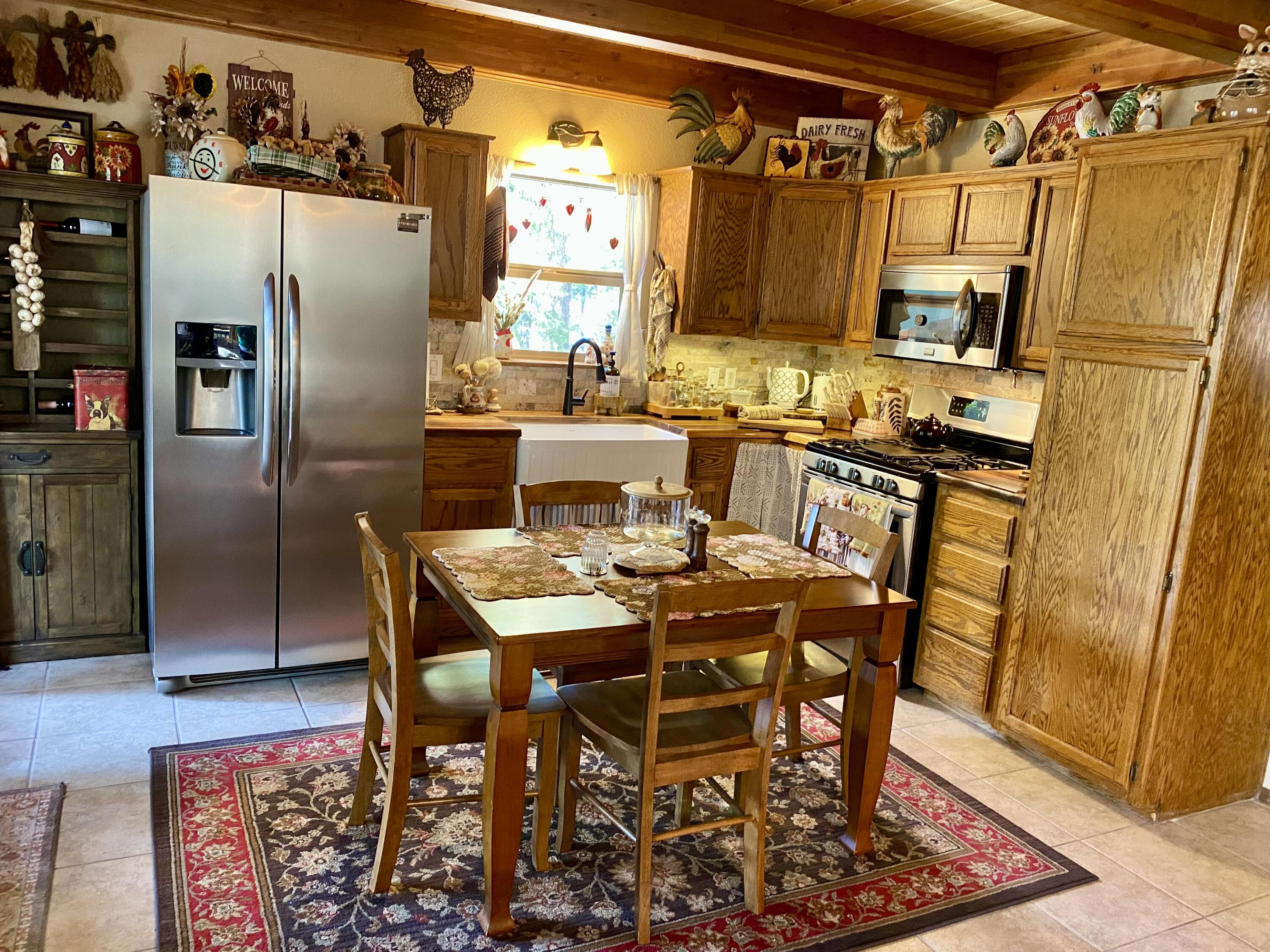 57968 Fox Drive Springville, CA 93265 - Photo 4 of 30 a kitchen with stainless steel appliances granite countertop a table chairs and a refrigerator