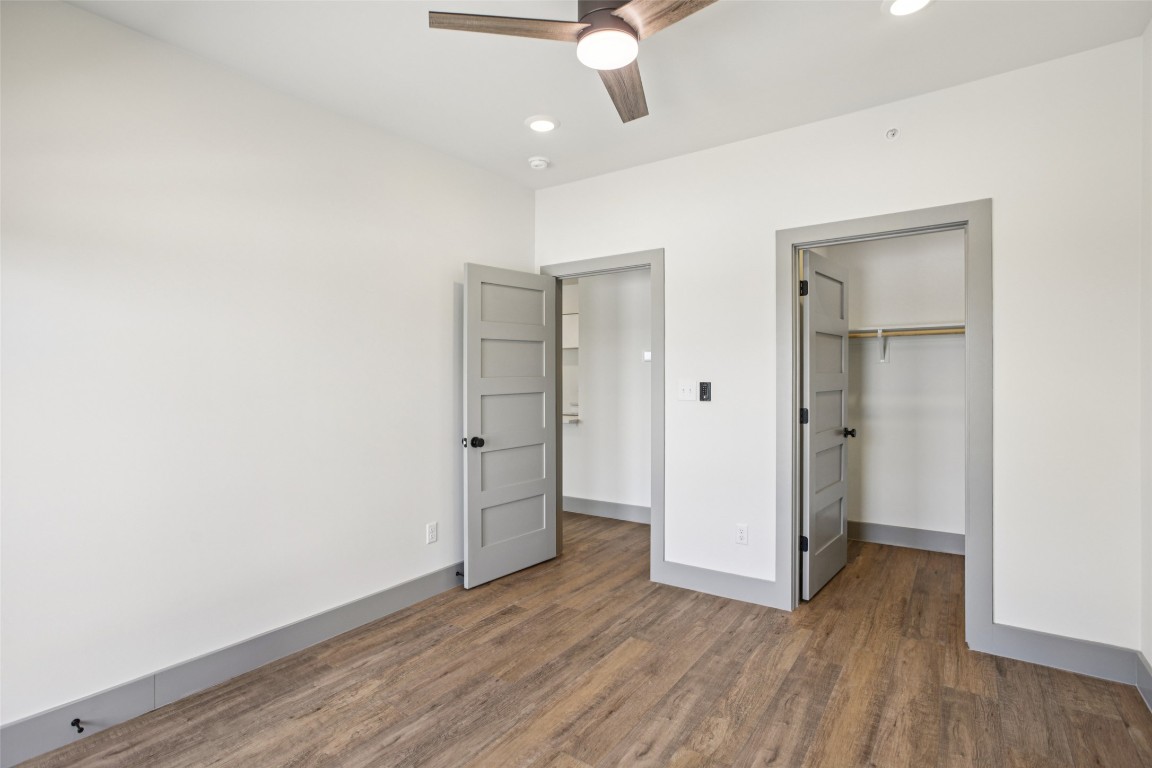 2450 Wickersham Lane, Unit 1917 Austin, TX 78741 - Photo 12 of 18 Unfurnished bedroom with dark wood-type flooring, a spacious closet, recessed lighting, and a ceiling fan