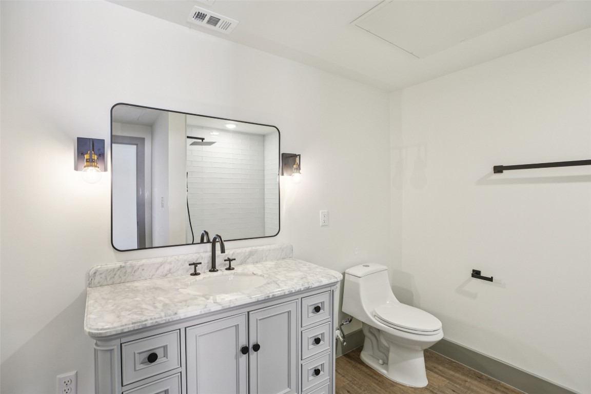 2450 Wickersham Lane, Unit 1917 Austin, TX 78741 - Photo 14 of 18 Full bath featuring vanity, dark wood-style flooring, and a shower