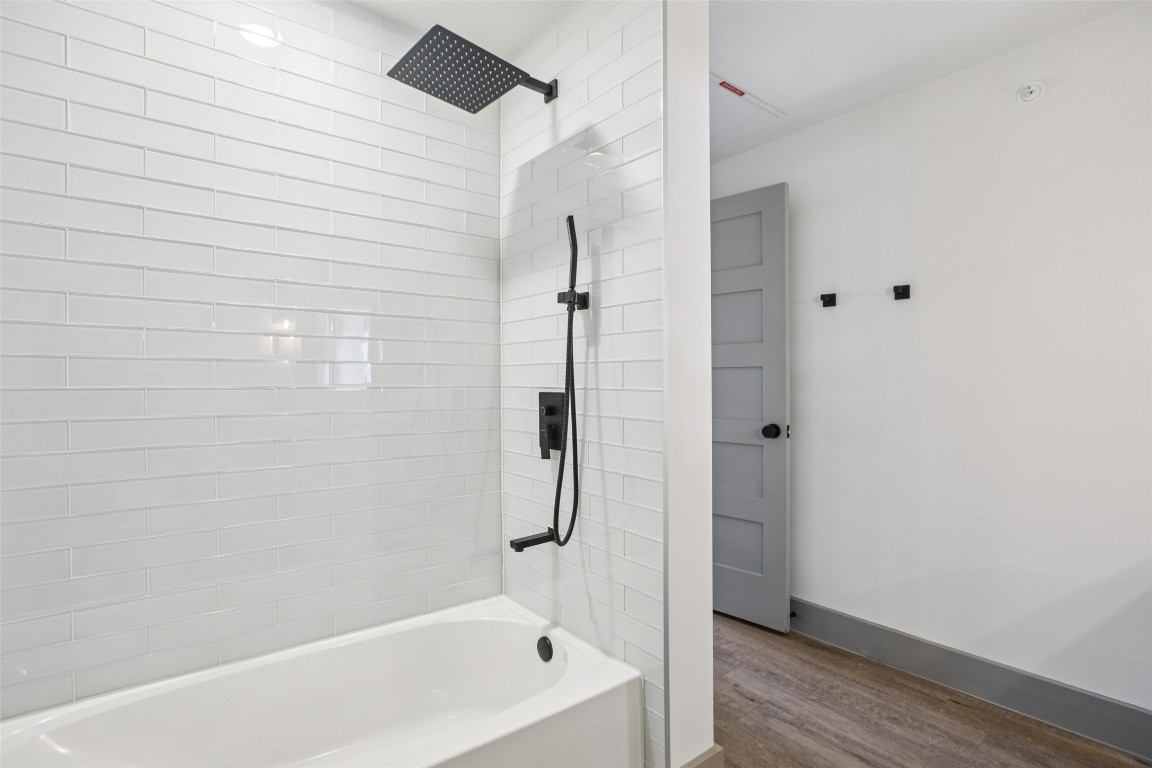 2450 Wickersham Lane, Unit 1917 Austin, TX 78741 - Photo 16 of 18 Bathroom featuring tub / shower combination and wood finished floors