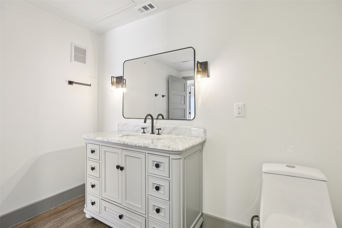 2450 Wickersham Lane, Unit 1917 Austin, TX 78741 - Photo 17 of 18 Half bath with vanity and dark wood-style floors