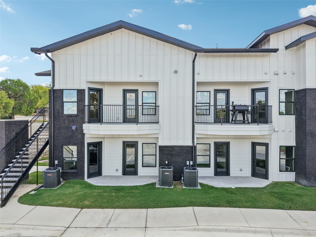 2450 Wickersham Lane, Unit 1917 Austin, TX 78741 - Photo 18 of 18 Rear view of house featuring board and batten siding, a balcony, a patio, and stairs