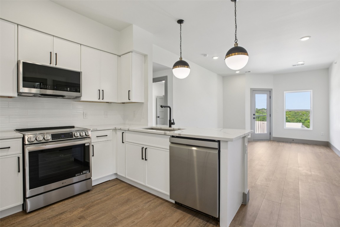 2450 Wickersham Lane, Unit 1917 Austin, TX 78741 - Photo 2 of 18 Kitchen with stainless steel appliances, decorative backsplash, white cabinets, dark wood-style flooring, and recessed lighting