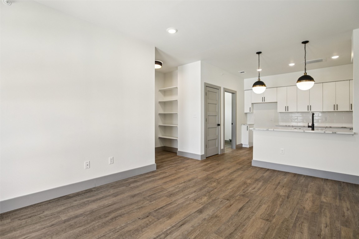 2450 Wickersham Lane, Unit 1917 Austin, TX 78741 - Photo 6 of 18 Unfurnished living room featuring dark wood-type flooring and recessed lighting