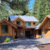 a view of a white house with large windows and a small yard