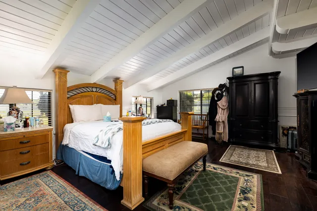 a bedroom with bed and wooden floor