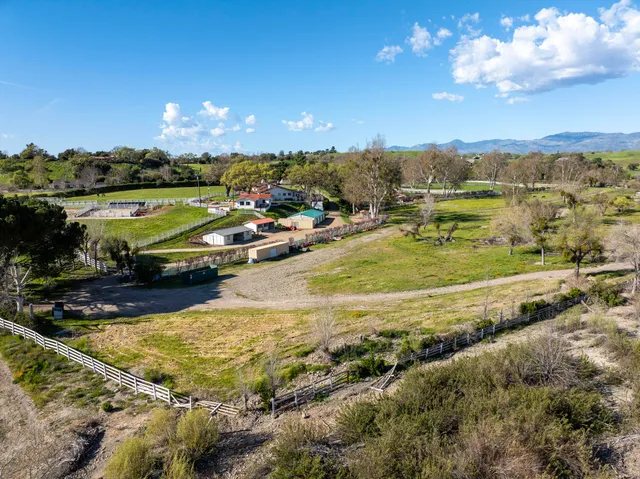an aerial view of residential houses with outdoor space and lake view