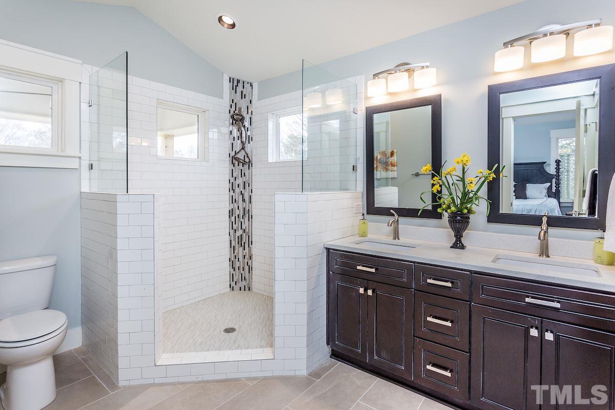830 Coleman Street Raleigh, NC 27610 - Photo 17 of 24 a bathroom with a granite countertop sink a toilet and a mirror