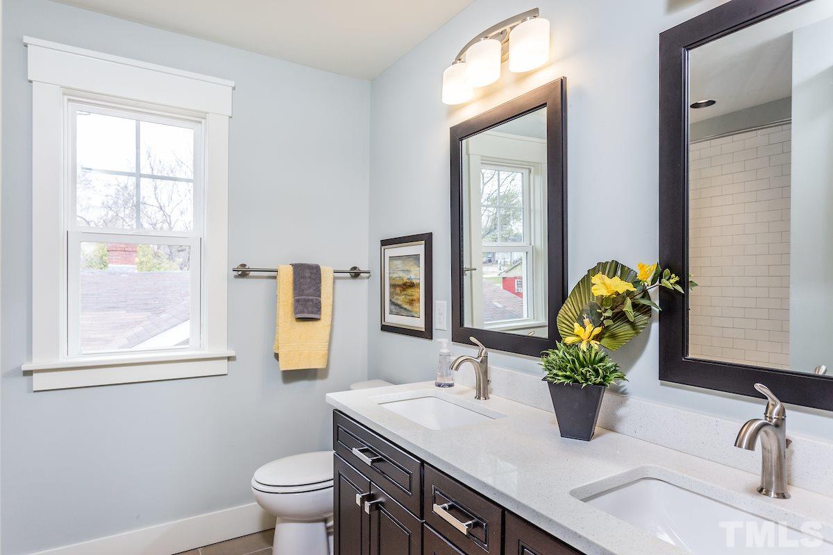 830 Coleman Street Raleigh, NC 27610 - Photo 21 of 24 a bathroom with a granite countertop sink a toilet and mirror