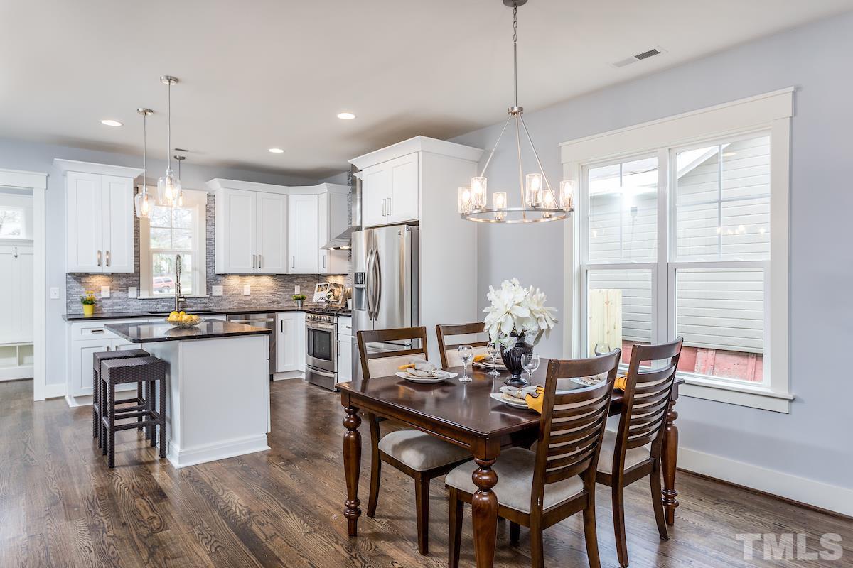 830 Coleman Street Raleigh, NC 27610 - Photo 8 of 24 a kitchen with a dining table chairs wooden floor cabinets and appliances