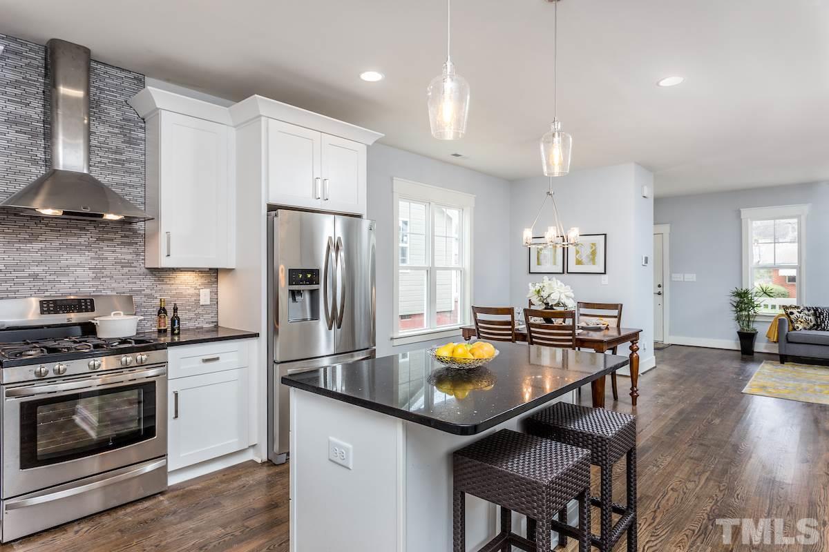 830 Coleman Street Raleigh, NC 27610 - Photo 10 of 24 a kitchen with a sink a stove and chairs