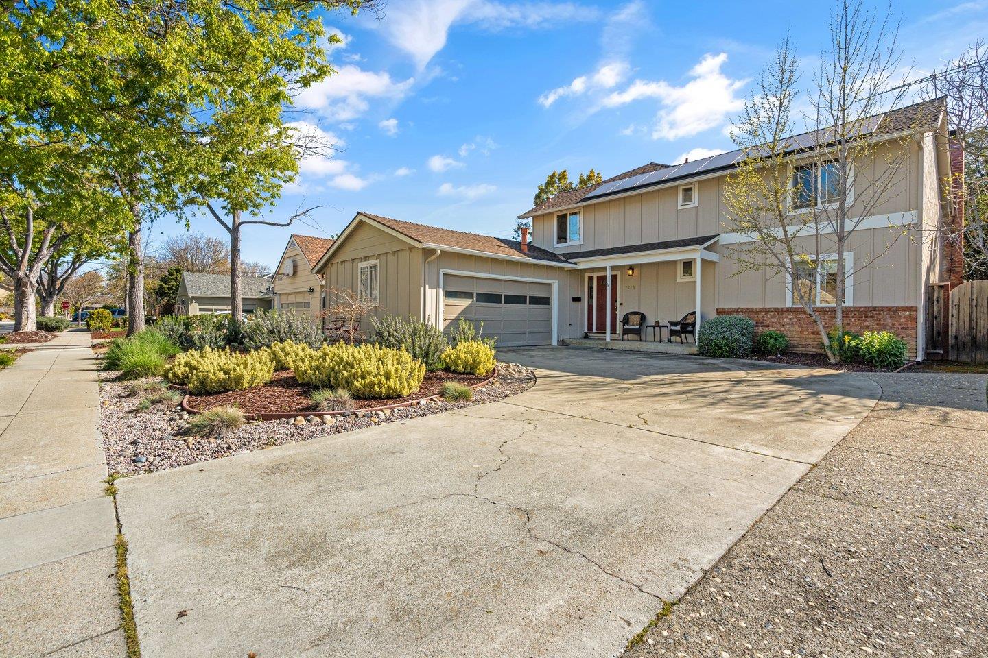 a front view of a house with a yard and potted plants