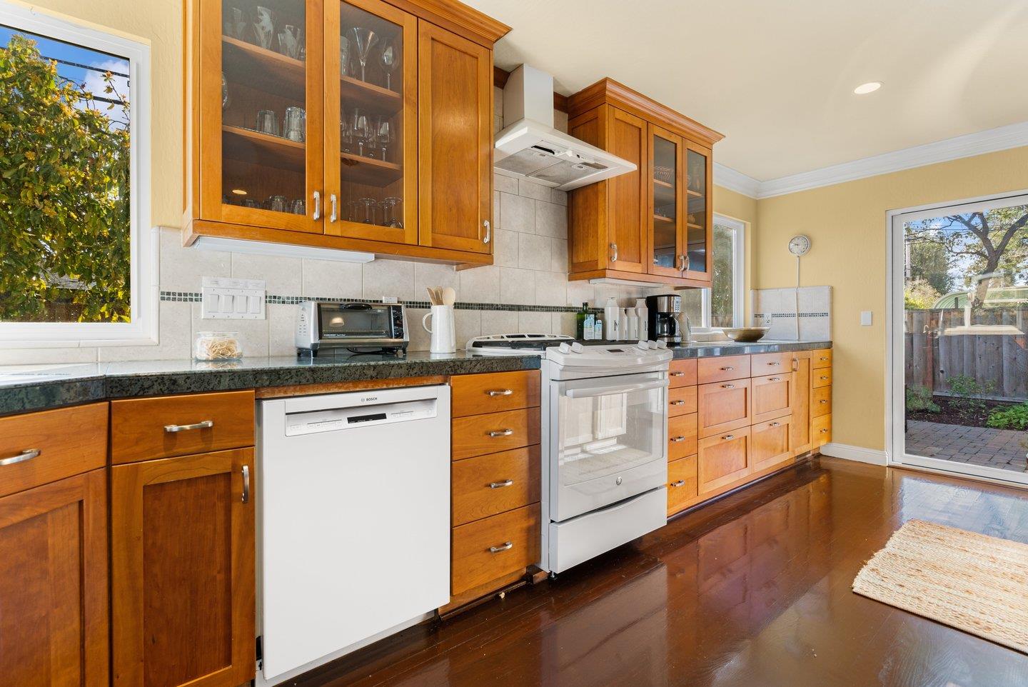 2248 Montezuma Drive Campbell, CA 95008 - Photo 10 of 36 a kitchen with stainless steel appliances granite countertop a stove a sink and white cabinets with wooden floor