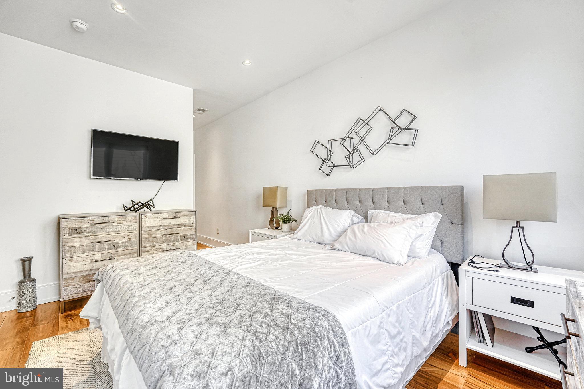 904 H Street Northeast, Unit 1 Washington, DC 20002 - Photo 7 of 17 a bedroom with a bed and a flat screen tv
