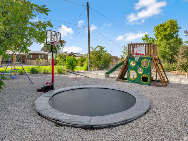 523 South Main Street Payson, UT 84651 - Photo 38 of 41 Spacious outdoor area with a ground-level trampoline, a playset featuring a slide and climbing wall, and a portable basketball hoop