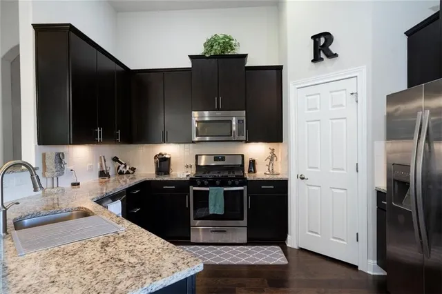 a kitchen with stainless steel appliances granite countertop a refrigerator and a sink