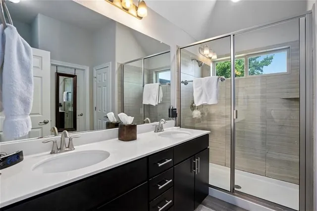 a bathroom with a double vanity sink mirror and shower