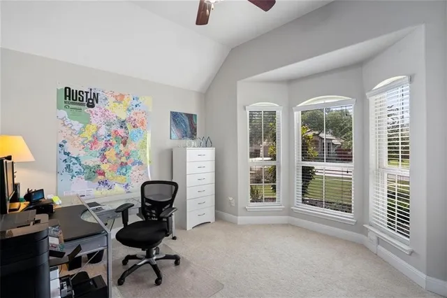 a view of a workspace with furniture and a window